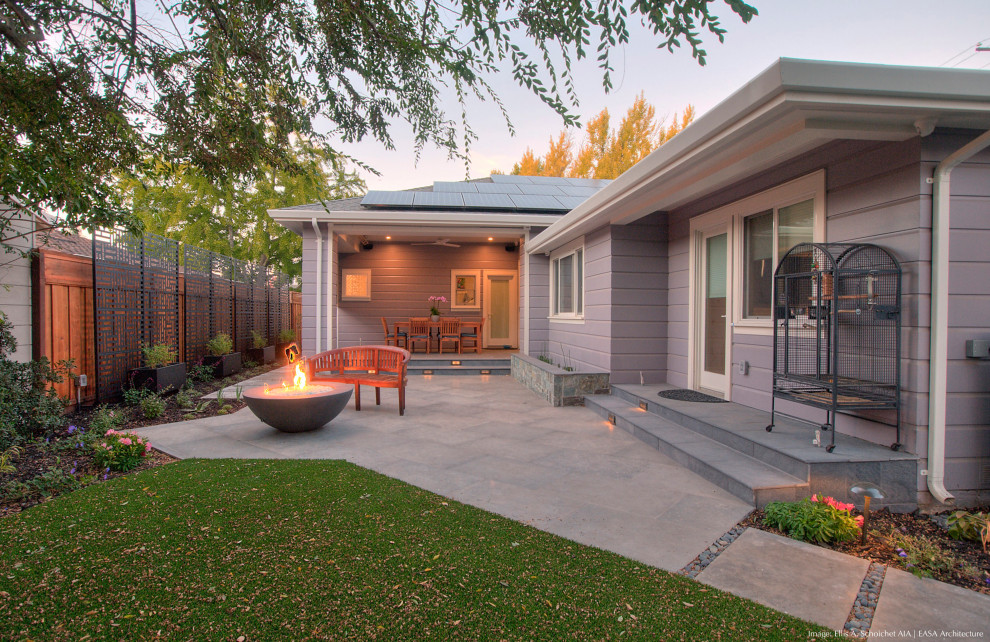 Inspiration for a small contemporary backyard patio in San Francisco with a fire feature, tile and a roof extension.