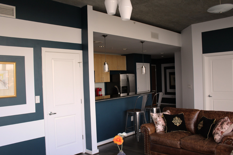 This is an example of a small industrial open concept living room in Houston with a home bar, blue walls, dark hardwood floors, no fireplace and a wall-mounted tv.
