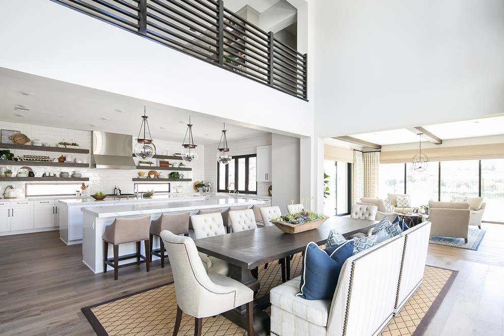 Example of a beach style medium tone wood floor great room design in San Diego with white walls and no fireplace