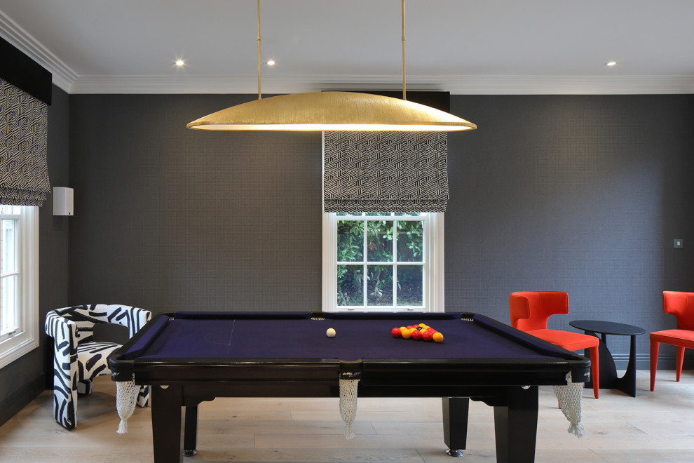 Immagine di un soggiorno design di medie dimensioni e chiuso con sala giochi, pareti nere e parquet chiaro