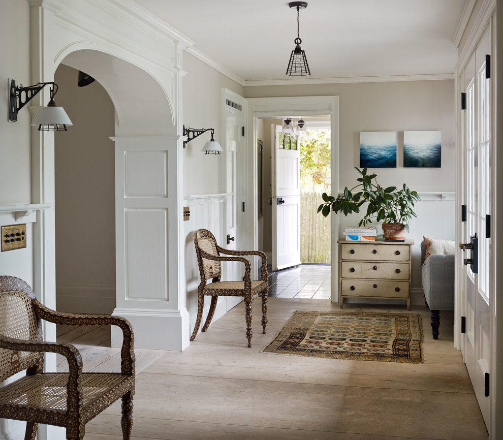 Design ideas for a mid-sized country foyer in New York with grey walls, limestone floors, a white front door and beige floor.