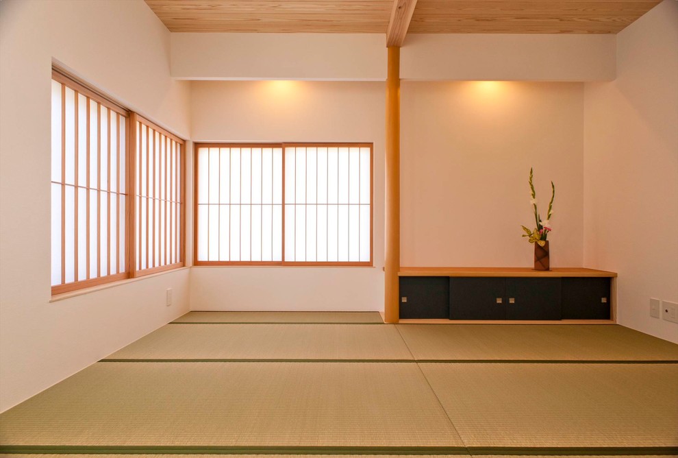 This is an example of an asian family room in Other with white walls, tatami floors and green floor.