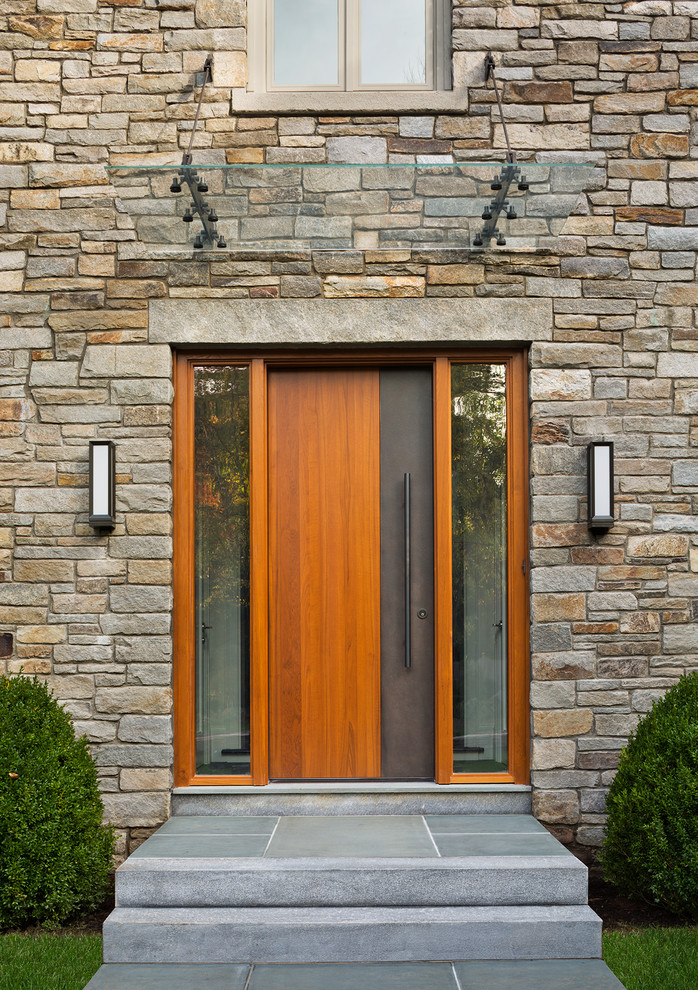Photo of a contemporary entryway in New York with a medium wood front door.