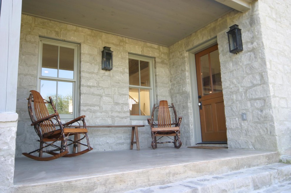 Inspiration for a mid-sized country backyard verandah in Austin with natural stone pavers and a roof extension.