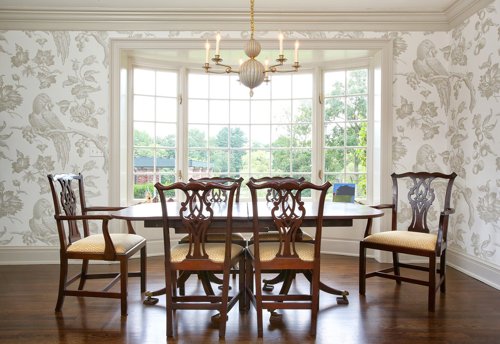 This is an example of a traditional dining room in New York with beige walls, dark hardwood floors and brown floor.