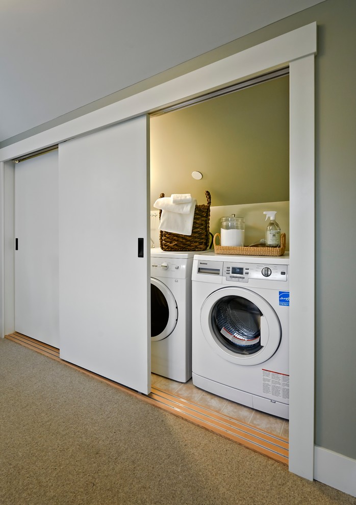 Traditional laundry room in Vancouver with a concealed washer and dryer.