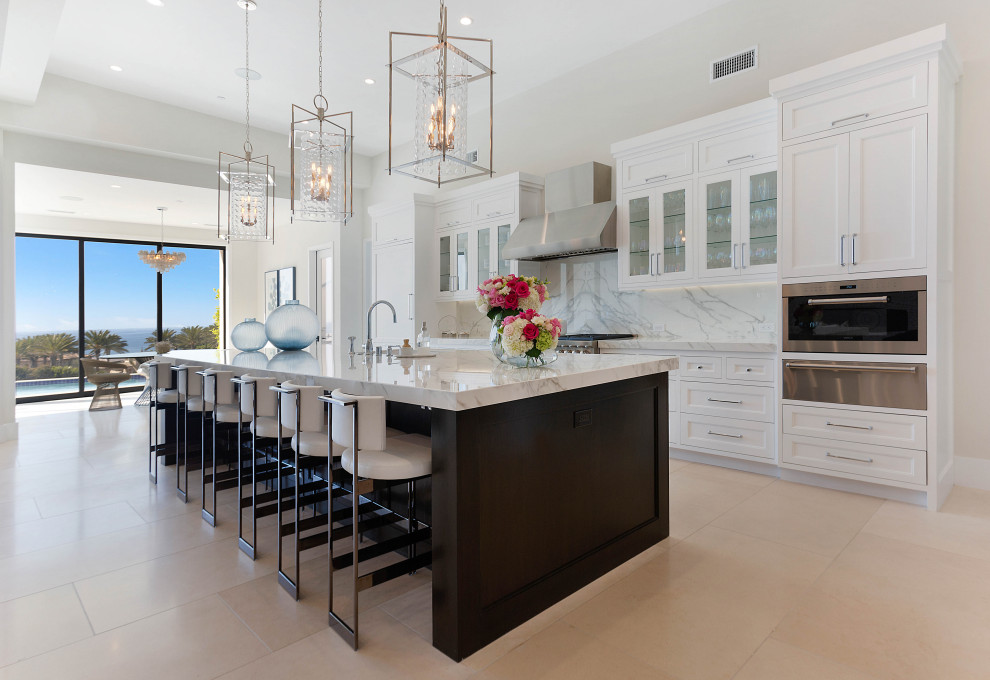 Design ideas for a large transitional single-wall eat-in kitchen in Orange County with recessed-panel cabinets, white cabinets, quartz benchtops, white splashback, stone slab splashback, with island and white benchtop.