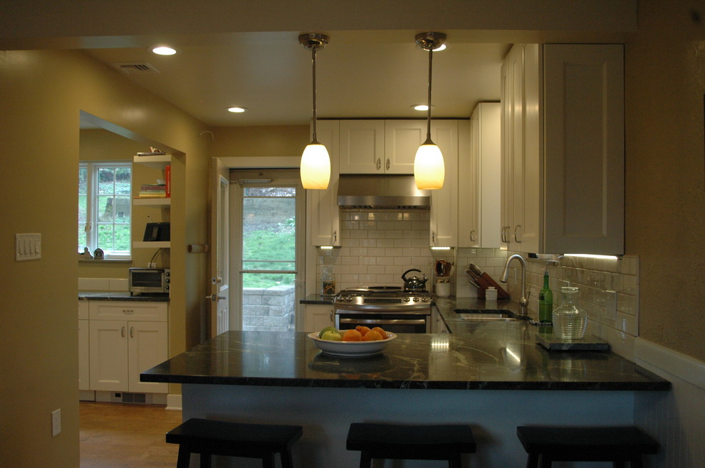 Kitchen - kitchen idea with shaker cabinets, white cabinets, white backsplash, stainless steel appliances, a peninsula and black countertops
