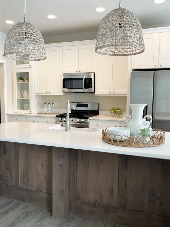 Mid-sized transitional galley vinyl floor and brown floor eat-in kitchen photo in Chicago with a farmhouse sink, shaker cabinets, white cabinets, quartz countertops, stainless steel appliances, an island and white countertops