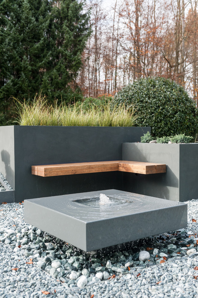 Photo of a contemporary garden in Other with a water feature and gravel.