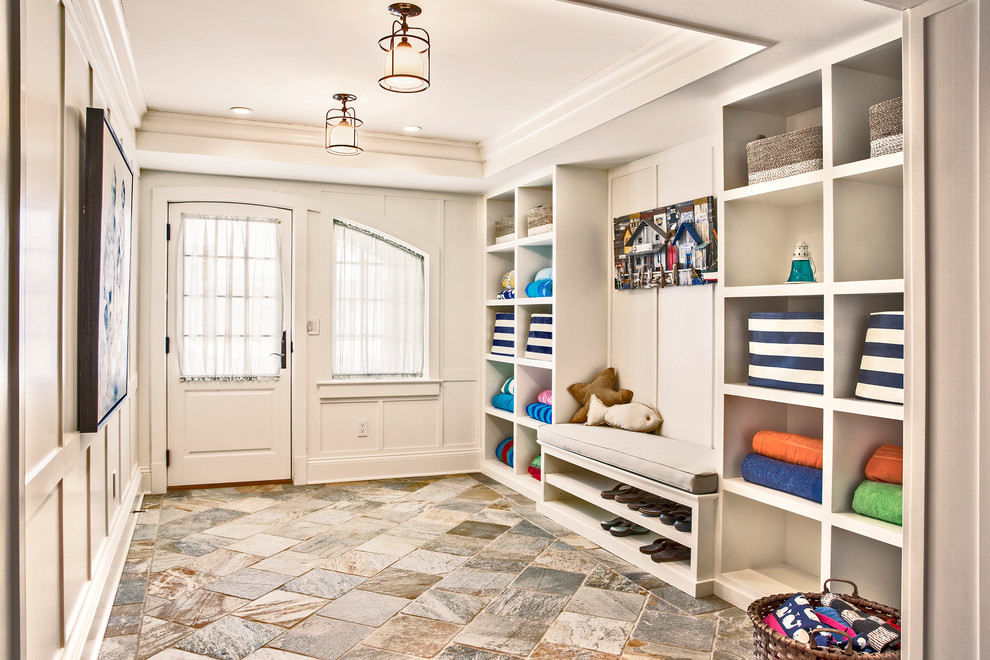 This is an example of a mid-sized beach style mudroom in New York with slate floors, a single front door, a white front door and white walls.