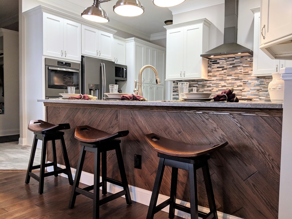 クリーブランドの中サイズのトランジショナルスタイルのおしゃれなダイニングキッチン (アンダーカウンターシンク、シェーカースタイル扉のキャビネット、白いキャビネット、御影石カウンター、マルチカラーのキッチンパネル、ガラスタイルのキッチンパネル、シルバーの調理設備、磁器タイルの床、グレーの床、グレーのキッチンカウンター) の写真