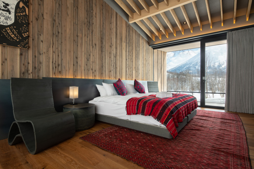 На фото: большая хозяйская спальня в стиле рустика с серыми стенами, полом из фанеры, бежевым полом, балками на потолке и деревянными стенами без камина