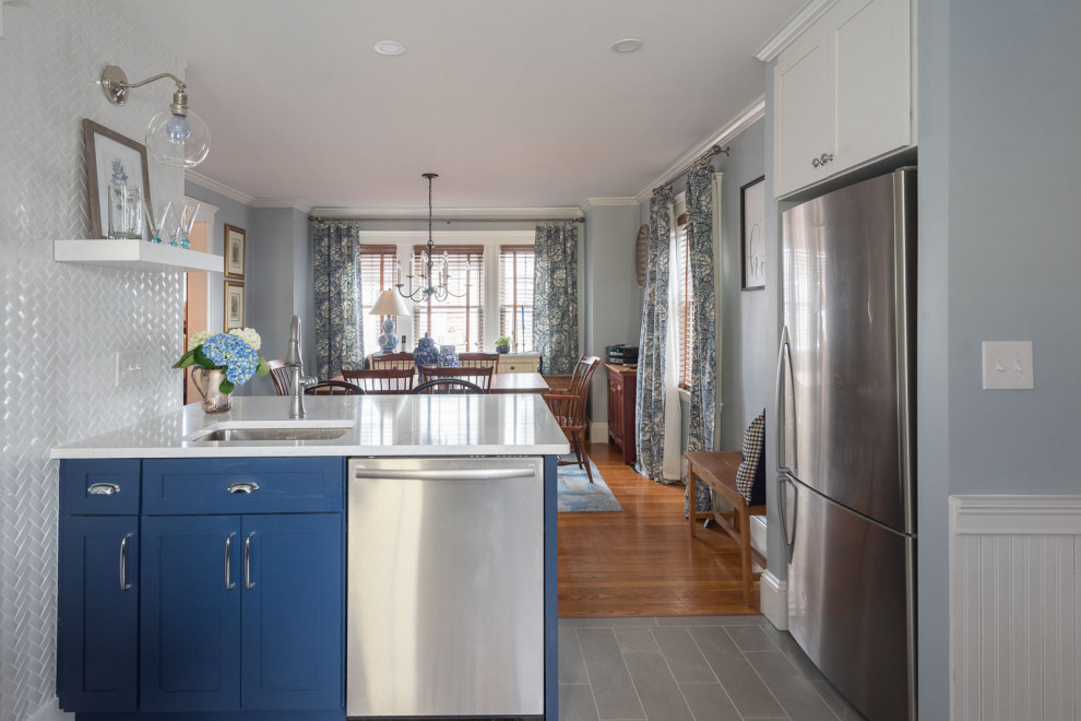 Mid-sized transitional u-shaped porcelain tile and gray floor eat-in kitchen photo in Boston with an undermount sink, shaker cabinets, blue cabinets, quartz countertops, white backsplash, subway tile backsplash, stainless steel appliances, a peninsula and white countertops