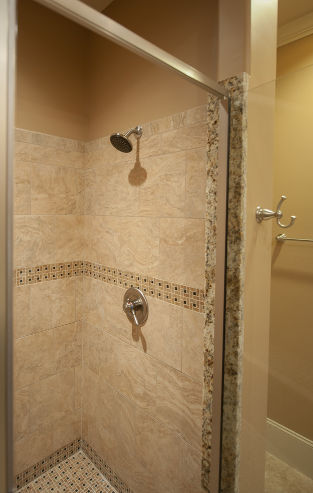 This is an example of a mid-sized transitional 3/4 bathroom in Other with raised-panel cabinets, dark wood cabinets, an alcove shower, a two-piece toilet, beige tile, beige walls, ceramic floors, an undermount sink and granite benchtops.