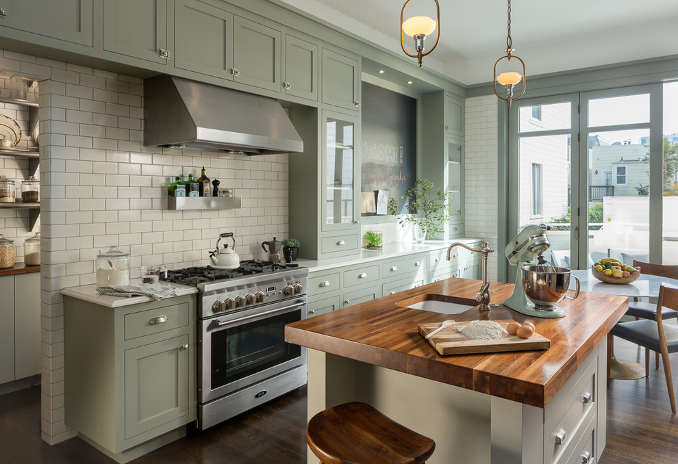 Design ideas for a traditional kitchen in San Francisco with an undermount sink, shaker cabinets, green cabinets, wood benchtops, white splashback, subway tile splashback, stainless steel appliances, dark hardwood floors and with island.