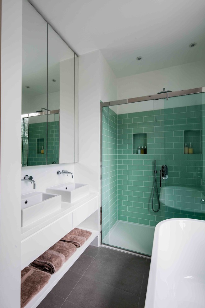 Mid-sized contemporary bathroom in London with a freestanding tub, an open shower, green tile, subway tile, white walls, a vessel sink, black floor and a sliding shower screen.