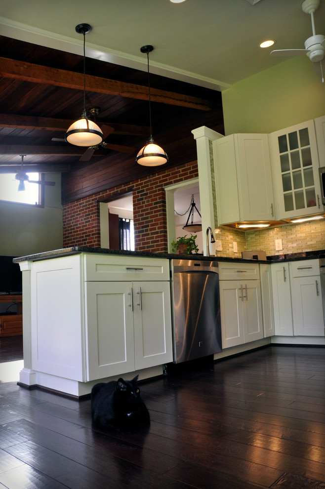 Inspiration for a mid-sized transitional u-shaped dark wood floor eat-in kitchen remodel in DC Metro with an undermount sink, shaker cabinets, white cabinets, granite countertops, yellow backsplash, glass tile backsplash, stainless steel appliances and a peninsula