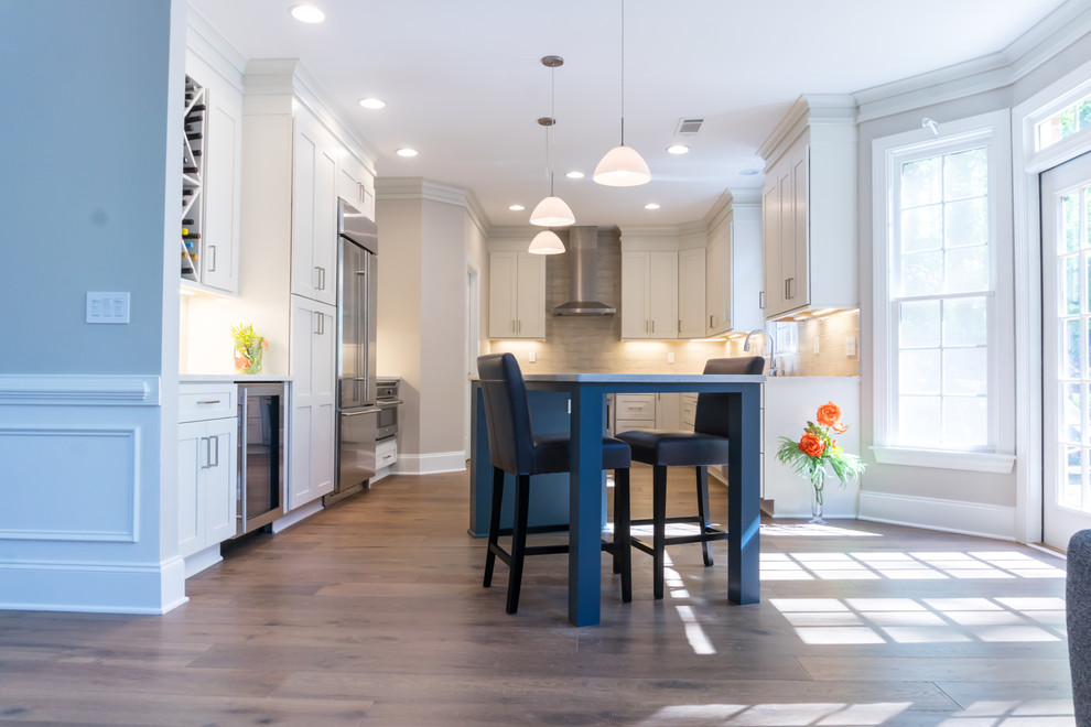 Enclosed kitchen - large transitional u-shaped dark wood floor and brown floor enclosed kitchen idea in Atlanta with a farmhouse sink, shaker cabinets, white cabinets, beige backsplash, stainless steel appliances, an island, white countertops, quartz countertops and cement tile backsplash