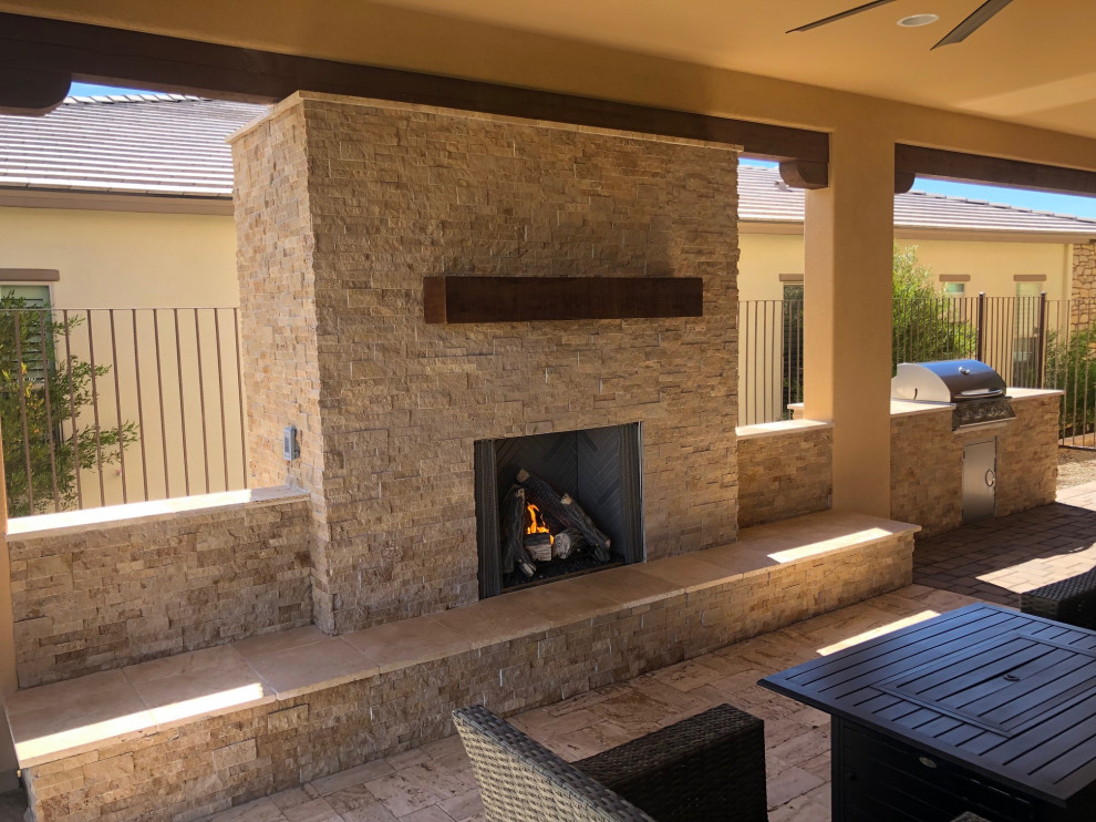 Patio - large transitional backyard stone patio idea in Phoenix with a fireplace and a roof extension