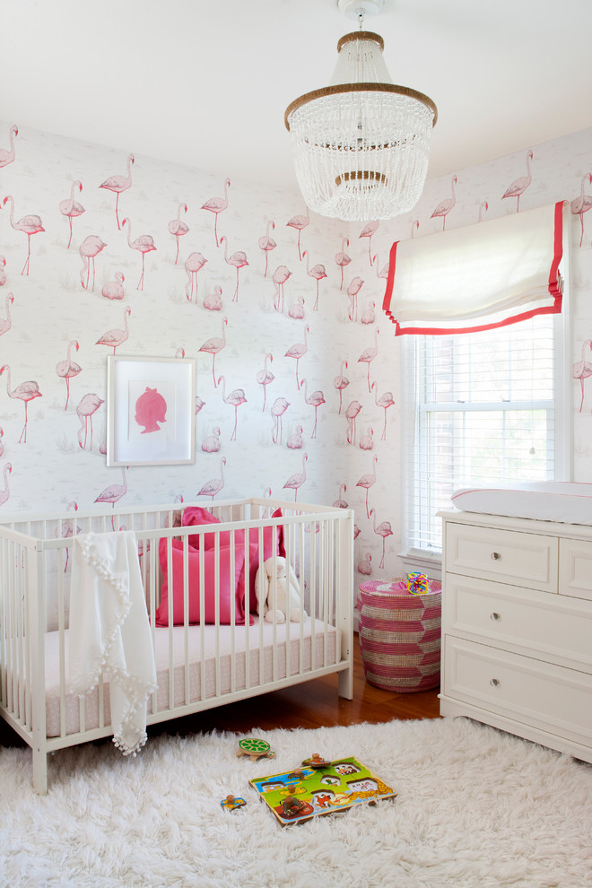 This is an example of a mid-sized transitional nursery for girls in New York with multi-coloured walls and medium hardwood floors.