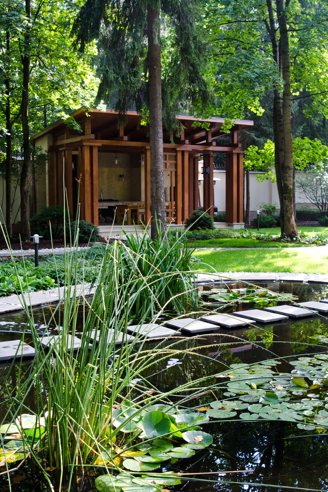 This is an example of a contemporary garden in Moscow with with pond.