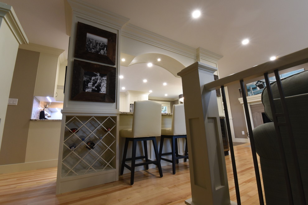 Inspiration for a mid-sized transitional u-shaped light wood floor and beige floor kitchen remodel in Calgary with an undermount sink, beaded inset cabinets, white cabinets, granite countertops, gray backsplash, ceramic backsplash, stainless steel appliances, two islands and gray countertops