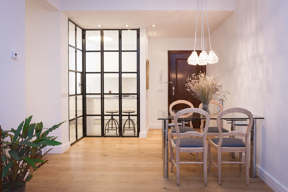 Diseño de comedor nórdico de tamaño medio cerrado sin chimenea con paredes blancas y suelo de madera clara