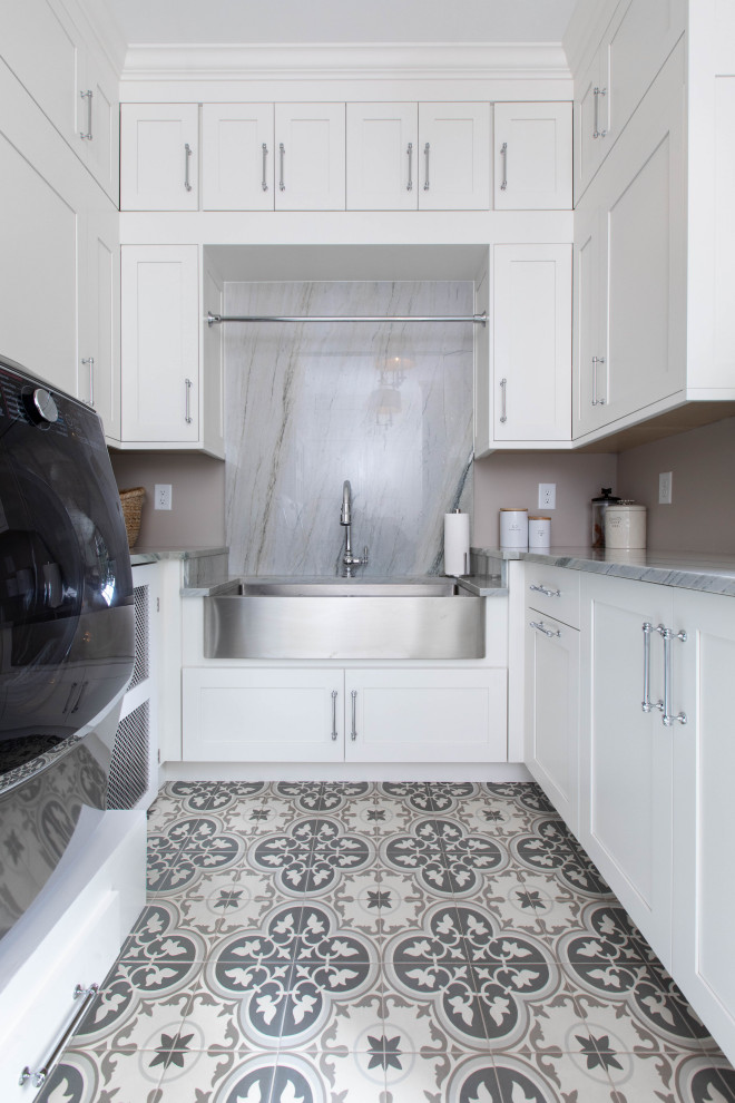Photo of a transitional u-shaped laundry room in Other with a farmhouse sink, shaker cabinets, white cabinets, marble benchtops and grey benchtop.