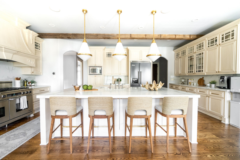 Design ideas for a transitional u-shaped kitchen in Atlanta with a farmhouse sink, raised-panel cabinets, beige cabinets, multi-coloured splashback, stainless steel appliances, medium hardwood floors, with island, brown floor, multi-coloured benchtop and exposed beam.