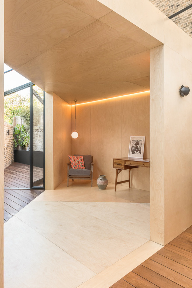 Scandinavian home office in London with beige walls, plywood floors and beige floor.