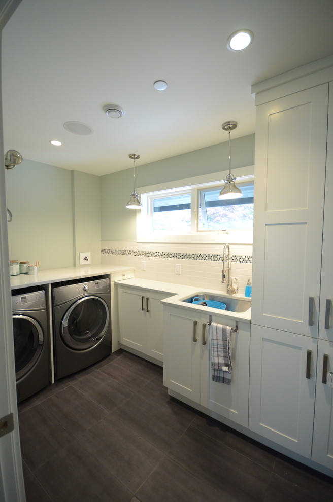 Large transitional l-shaped laundry room in Vancouver with an undermount sink, shaker cabinets, white cabinets, quartz benchtops, grey splashback and glass tile splashback.