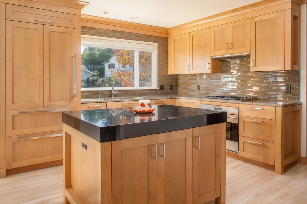 Design ideas for a transitional kitchen in San Francisco with an undermount sink, shaker cabinets, medium wood cabinets, granite benchtops, brown splashback, matchstick tile splashback, panelled appliances, light hardwood floors and with island.