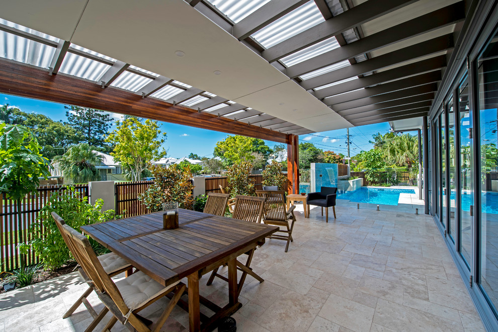 This is an example of a small contemporary patio in Brisbane with natural stone pavers.