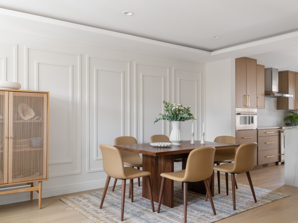 Mid-sized trendy light wood floor, brown floor and wall paneling kitchen/dining room combo photo in DC Metro with yellow walls