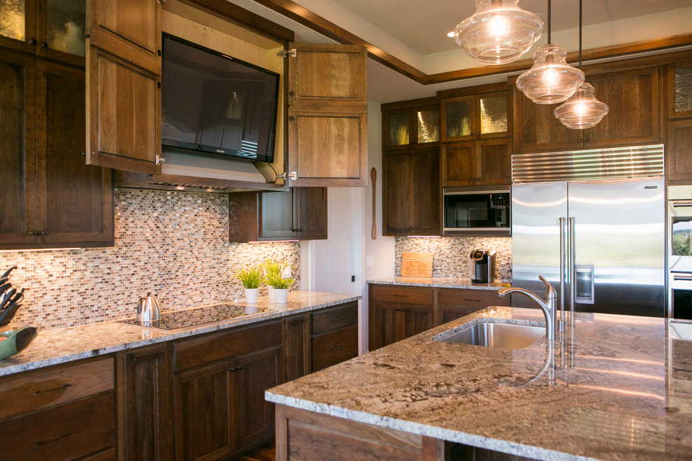 Inspiration for a transitional dark wood floor and brown floor open concept kitchen remodel with recessed-panel cabinets, dark wood cabinets, granite countertops, beige backsplash, glass sheet backsplash and an island