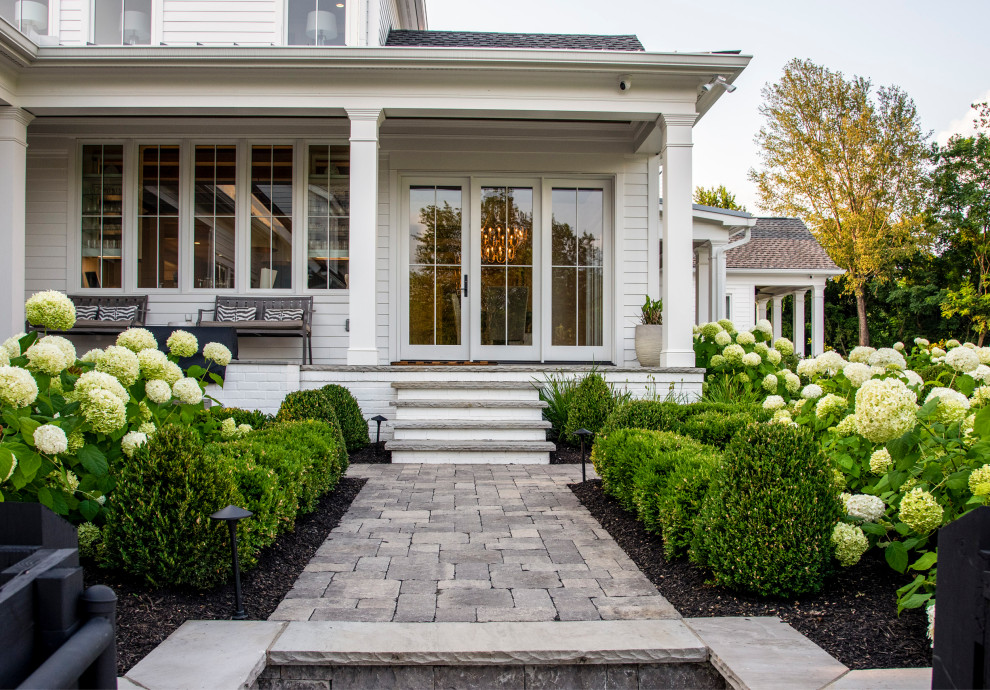 Inspiration for a large farmhouse side veranda in Nashville with natural stone paving and a roof extension.