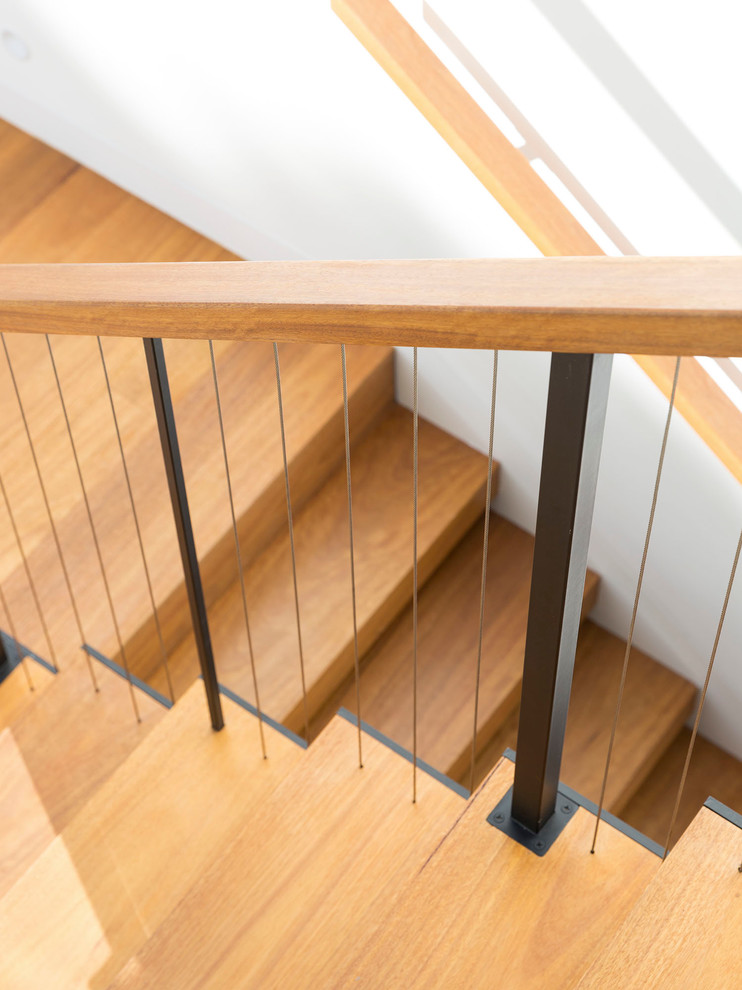 This is an example of a large contemporary wood floating staircase in Melbourne with open risers.