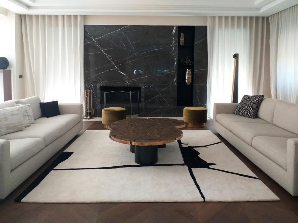 Ejemplo de sala de estar abierta moderna extra grande con paredes beige, suelo de madera en tonos medios, marco de chimenea de piedra, papel pintado y alfombra