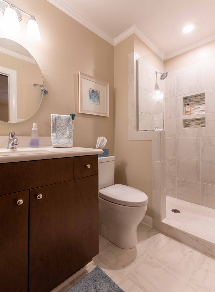 Photo of a small transitional master bathroom in Other with flat-panel cabinets, dark wood cabinets, an alcove shower, a one-piece toilet, white tile, ceramic tile, beige walls, ceramic floors, an integrated sink, solid surface benchtops, white floor, a hinged shower door, multi-coloured benchtops, a niche, a single vanity and a built-in vanity.