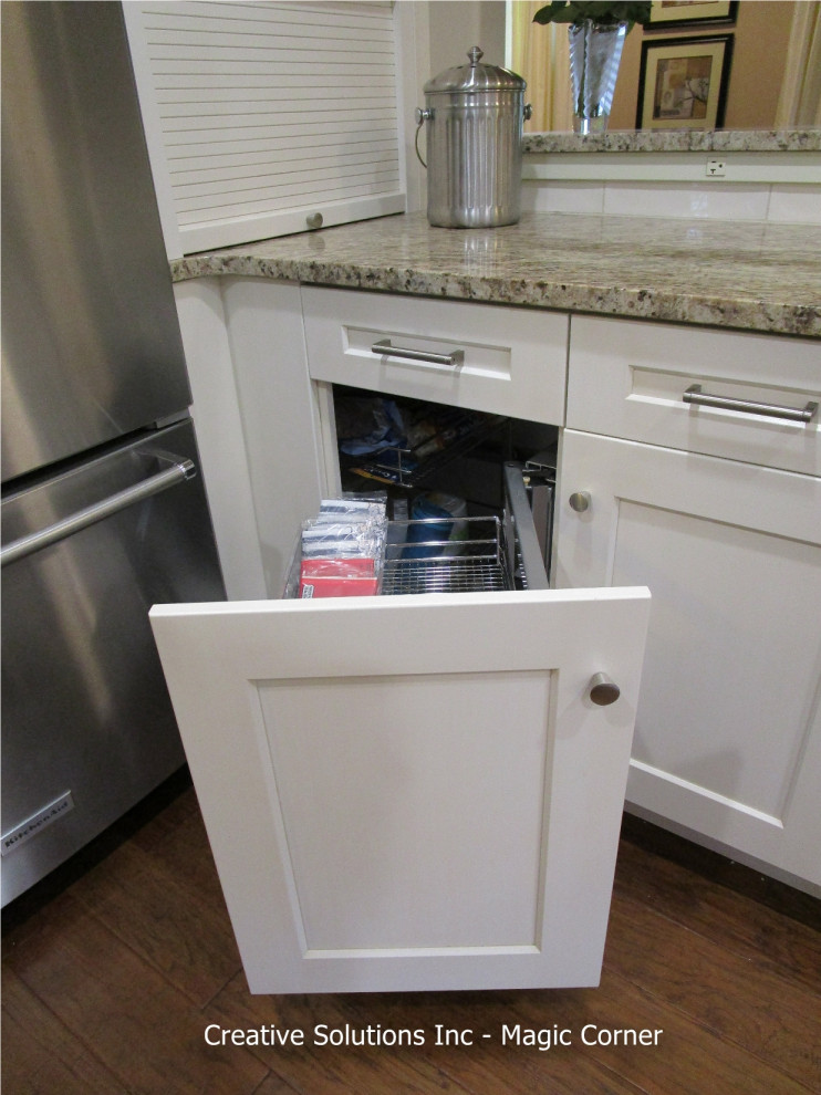 Mid-sized transitional l-shaped medium tone wood floor and brown floor eat-in kitchen photo in Chicago with flat-panel cabinets, white cabinets, granite countertops, white backsplash, subway tile backsplash, stainless steel appliances, a peninsula and brown countertops
