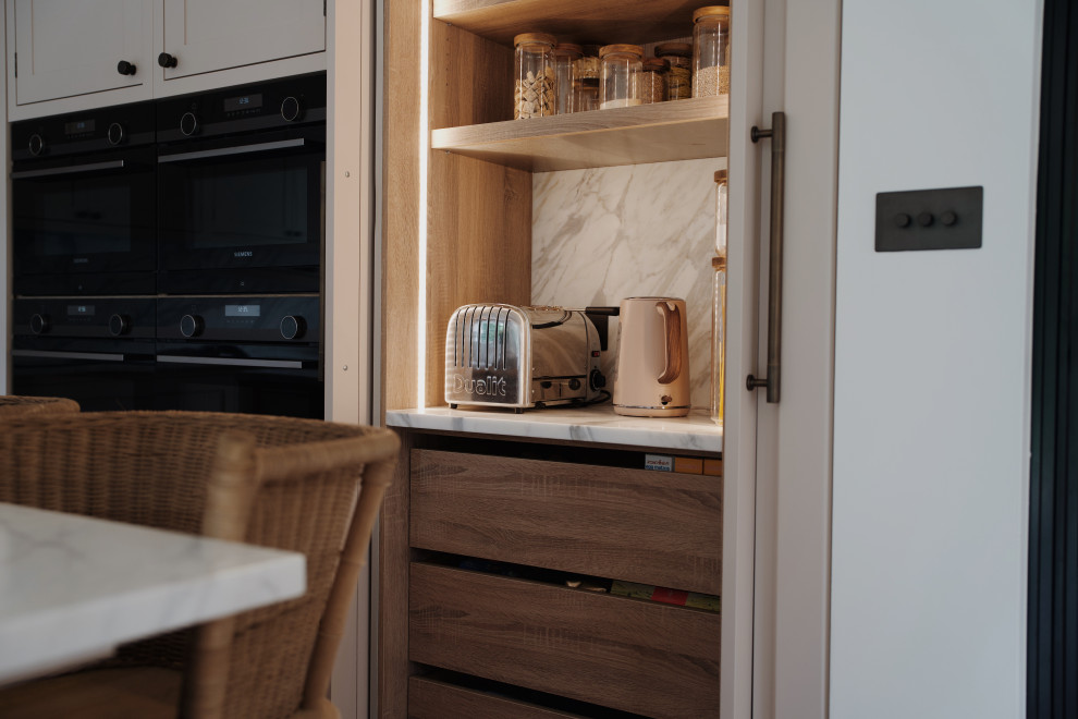 This is an example of a medium sized classic l-shaped kitchen in London with a submerged sink, shaker cabinets, pink cabinets, quartz worktops, white splashback, an island and white worktops.