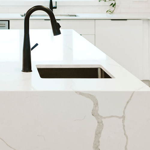 Inspiration for a large modern l-shaped open plan kitchen in Montreal with an undermount sink, flat-panel cabinets, medium wood cabinets, quartz benchtops, white splashback, ceramic splashback, stainless steel appliances, ceramic floors, with island, grey floor and white benchtop.