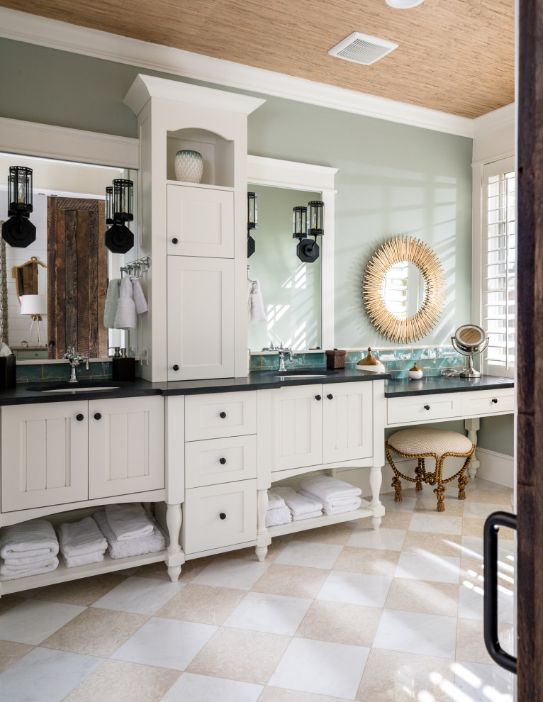 This is an example of a mid-sized traditional master bathroom in Houston with white cabinets, blue tile, subway tile, blue walls, beige floor, black benchtops, a double vanity, a built-in vanity, wood, furniture-like cabinets and an undermount sink.