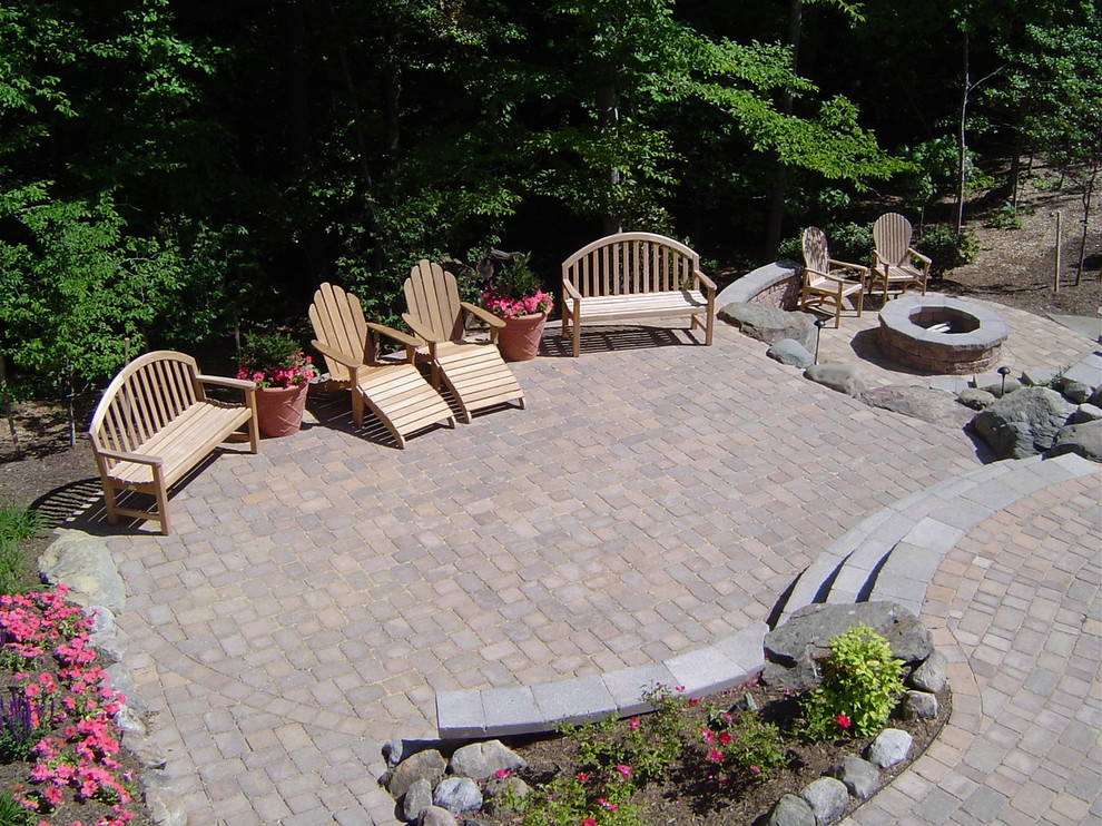 This is an example of a large traditional backyard patio in Baltimore with concrete pavers and no cover.