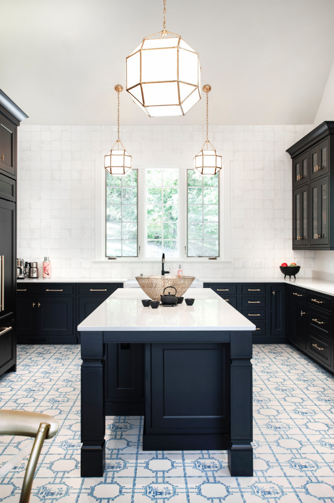 Photo of an expansive eclectic u-shaped kitchen/diner in Nashville with a belfast sink, beaded cabinets, black cabinets, engineered stone countertops, white splashback, ceramic splashback, integrated appliances, painted wood flooring, an island, blue floors and white worktops.