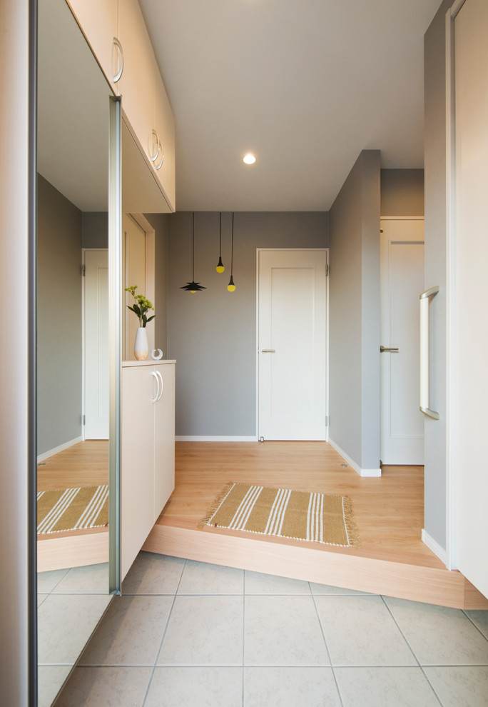 This is an example of a scandinavian entryway in Other with grey walls and grey floor.