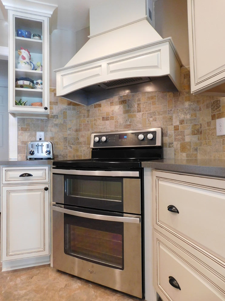 Inspiration for a mid-sized transitional galley vinyl floor enclosed kitchen remodel with a farmhouse sink, raised-panel cabinets, beige cabinets, solid surface countertops, multicolored backsplash, stone tile backsplash, stainless steel appliances and no island