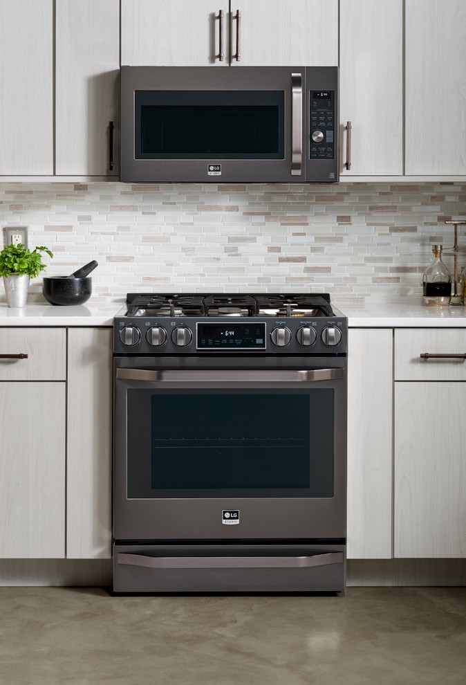 Stainless steel transitional slide-in gas kitchen photo in New York