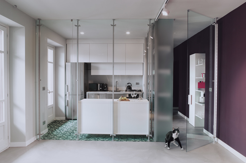 This is an example of a mid-sized contemporary galley separate kitchen in Turin with a single-bowl sink, flat-panel cabinets, white cabinets, laminate benchtops, white splashback, porcelain splashback, stainless steel appliances, cement tiles, with island and green floor.